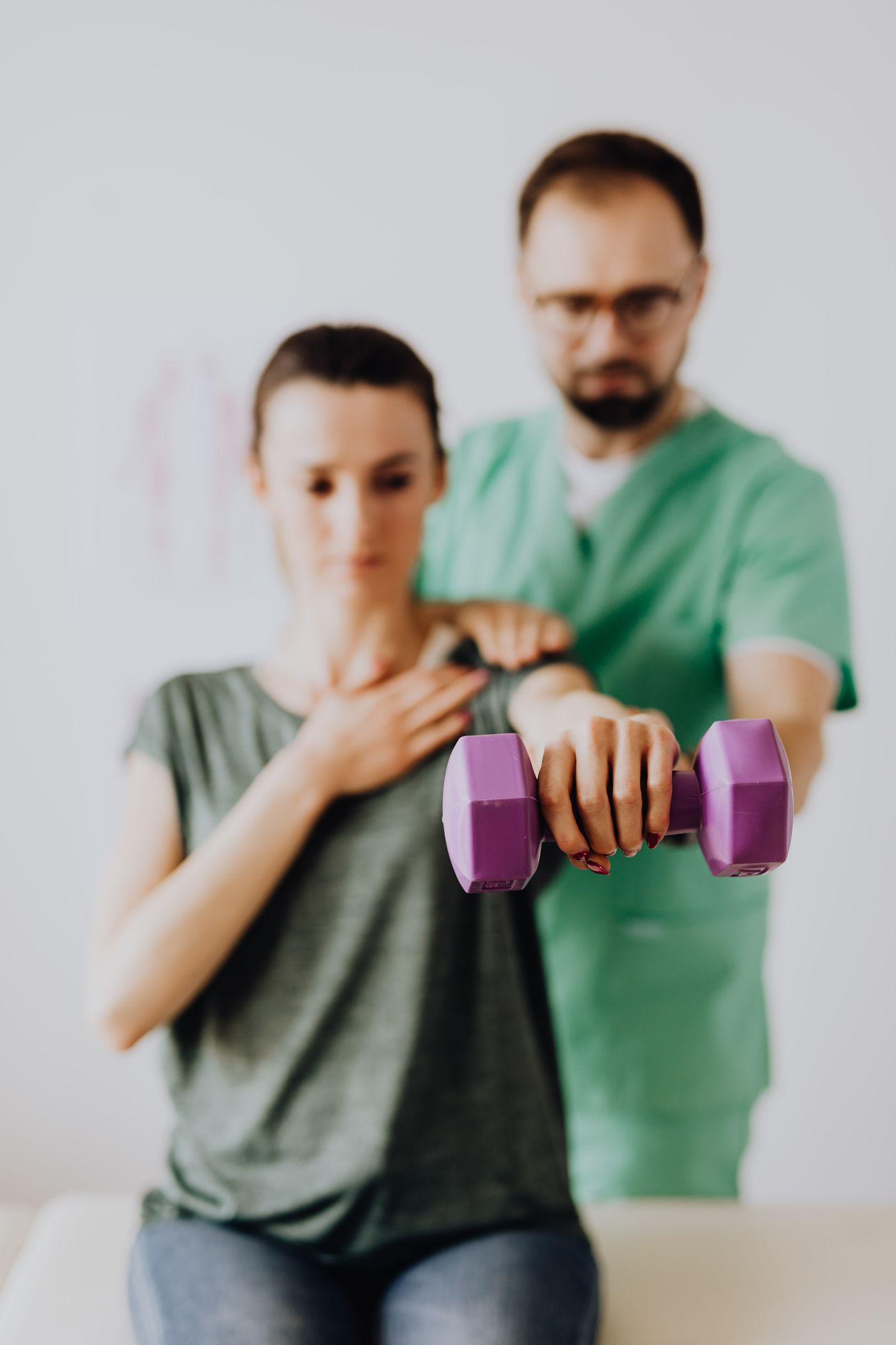 Therapist guiding a patient through a supported strength exercise