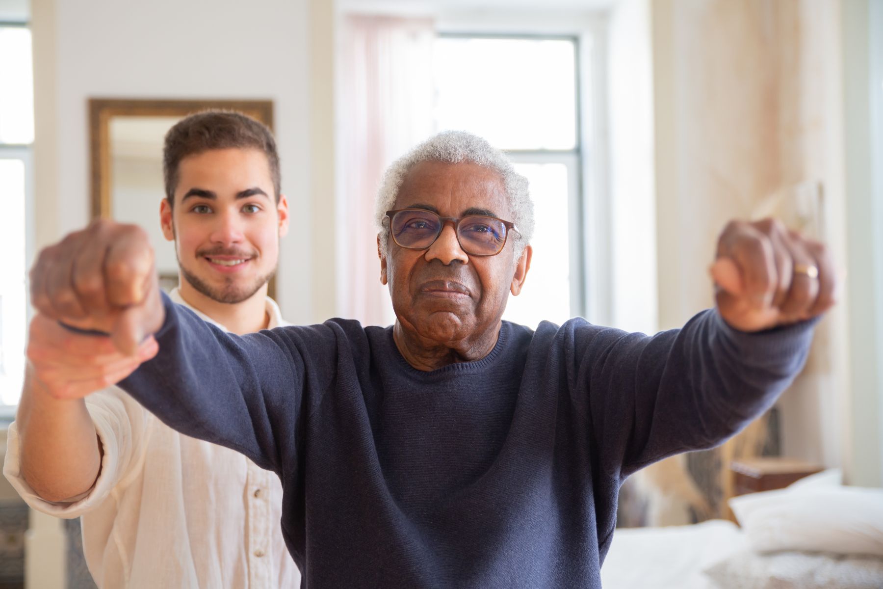 Therapist encouraging an older man during a strength exercise